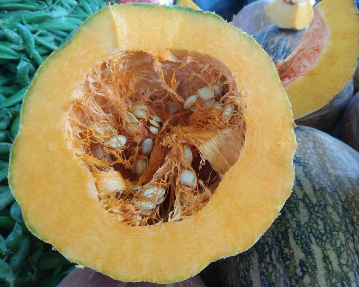 Citrouille coupée en deux montrant la chair orange et les graines au centre